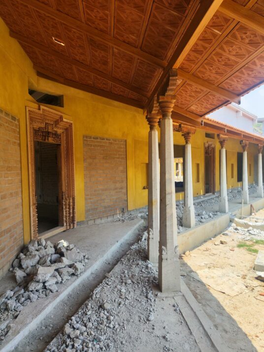 A photo of the office building under construction, with a Mangalore-tiled roof and traditional Indian architecture design features 