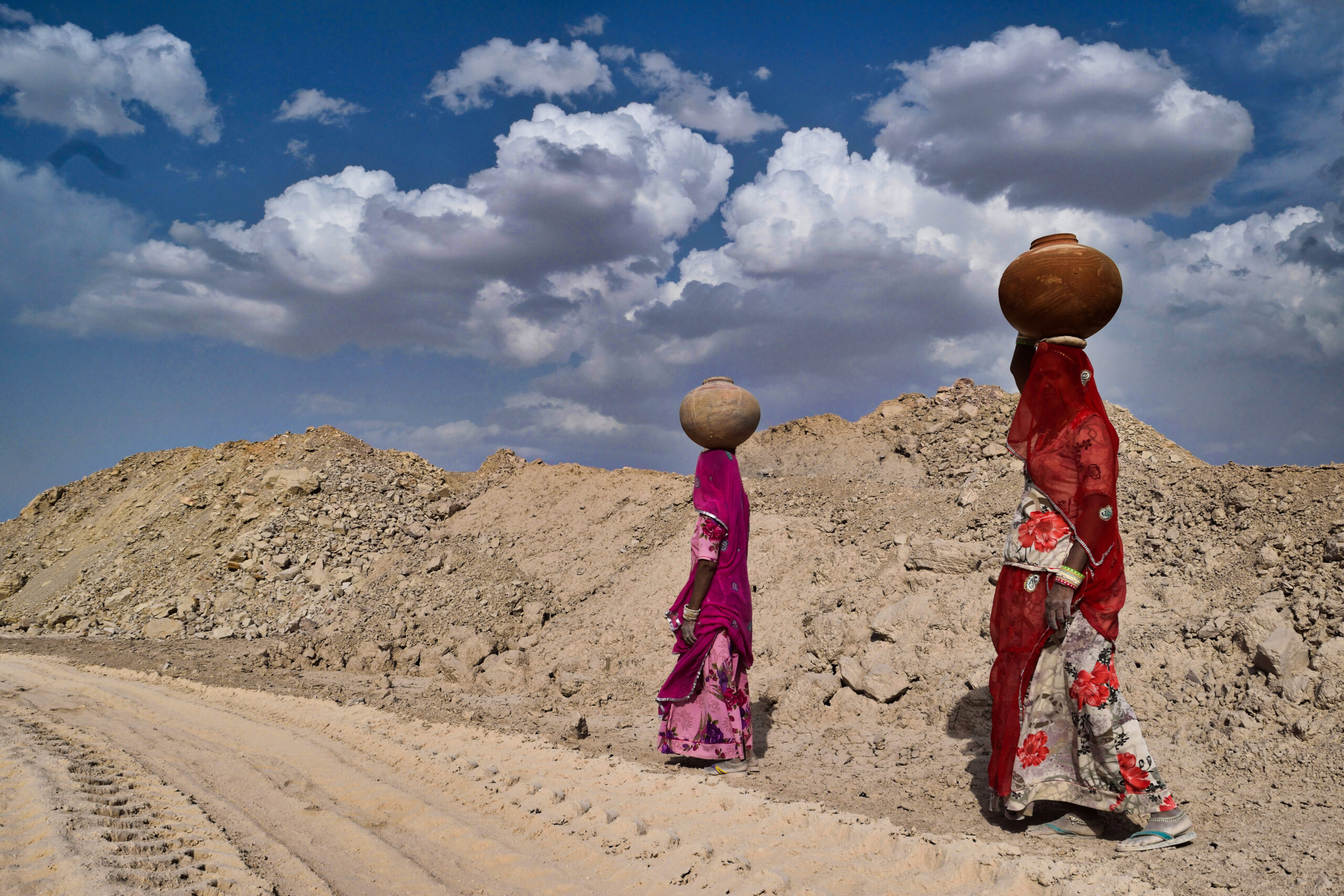 Two women going back home after filling water from well