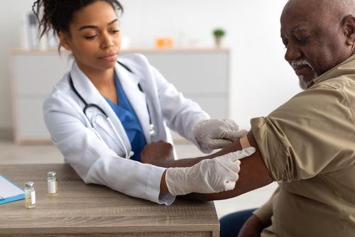 Woman giving an older man a vaccine