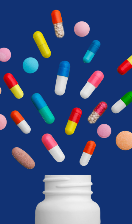 Pills outside of a bottle over navy blue background